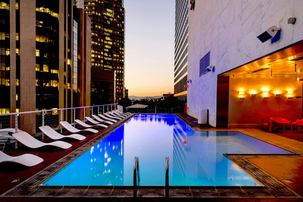 An image of a swimming pool with the chairs depicting all inclusive hotels in Vienna
