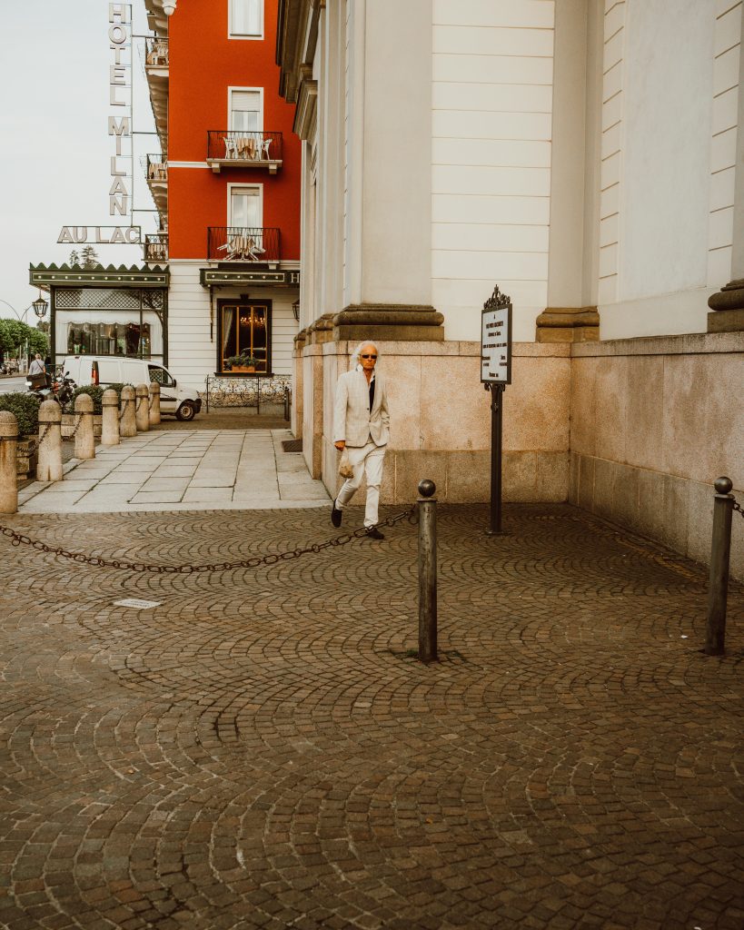 An image of a hotel with a passerby at one of the 4-star adults-only hotels in Klagenfurt