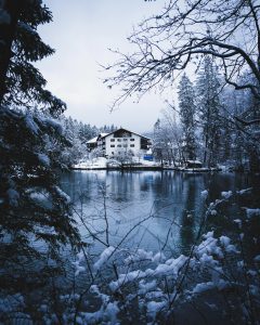 An image of one of the best winter hotels in Klagenfurt amidst water and trees.
